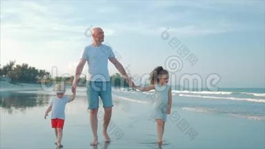 <strong>幸福</strong>的父亲、女儿和儿子在日落时在海滩上玩和玩。 动作缓慢。 <strong>幸福</strong>家庭