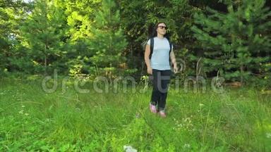女游客漫步在森林的空地上。