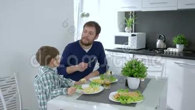 健康饮食，小男孩在家庭早餐时喂妈妈