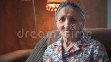 一位80-90岁的老妇人在家中的肖像。 老奇太太满脸皱纹，看着摄像机。 详细情况
