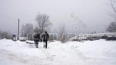 白雪皑皑的冬天，残疾人骑师领路，牵着一匹黑马在路上。 男人有假肢而不是