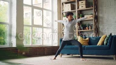 运动女孩正在做一系列的力量和伸展瑜伽练习在家里的个人练习。 自我