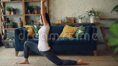 苗条的亚洲女运动员正在家中练习分腿，<strong>坐在地板上</strong>，然后在个人练习中向前弯曲