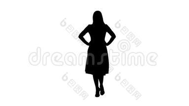 剪影女人穿着连衣裙，双手放在臀部，一边看镜头，一边走路。