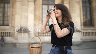 巴黎，漂亮的女人在背景上用胶卷相机拍照。 巴黎的旧建筑背景
