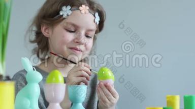 少女为复活节准备装饰品。 用刷子抹复活节彩蛋，笑得<strong>不好</strong>意思
