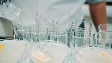专业的酒保在酒吧准备鸡尾酒。 酒吧服务员准备鸡尾酒，在玻璃杯中加入冰块。
