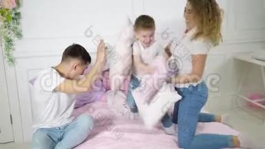 小家庭：<strong>爸爸妈妈</strong>和小儿子在床上玩枕头大战。