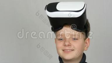 带着虚拟现实或虚拟现实眼镜的青少年男孩，他的头上戴着虚拟现实眼镜，在<strong>演播室</strong>的白色背景下玩得很开心