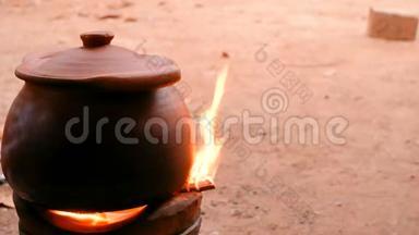 泥锅位于壁炉上，有木柴和烟。 传统烹饪方法