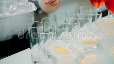 专业的酒保在酒吧准备鸡尾酒。 酒吧服务员准备鸡尾酒，在玻璃杯中加入冰块。