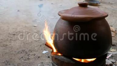 泥锅位于壁炉上，有木柴和烟。 传统<strong>烹饪方法</strong>
