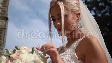 快乐的新娘带着婚礼花束漫步公园。 <strong>天气晴朗</strong>