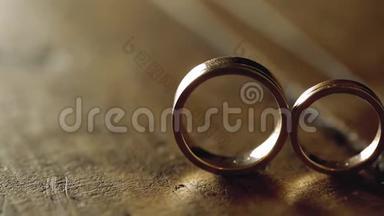 <strong>木质地板</strong>上的金色结婚戒指，背光的宏观特写镜头，耀斑，钻石首饰