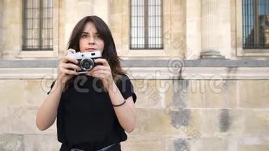 巴黎，法国漂亮的女人用胶卷相机拍照。 巴黎的旧建筑背景