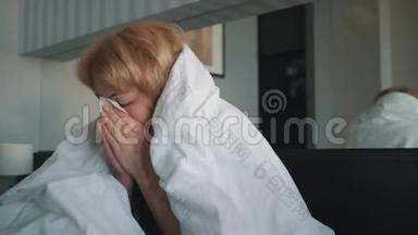 一个<strong>感冒</strong>的女人，感觉不好，吹进鼻子里，裹着一条白色的毯子。 医生`医疗帮助