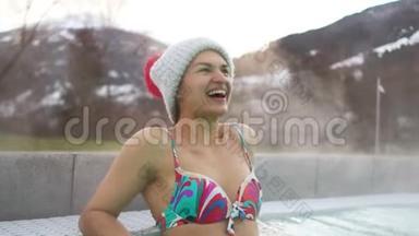 一个戴着帽子、穿着泳装的漂亮黑发女人的肖像。那女孩在山上泡温泉。滑雪胜地