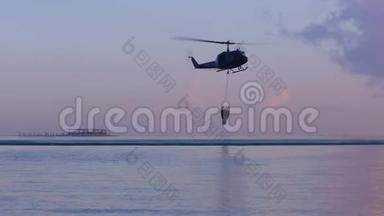 救援直升机将水收集到海里，飞向灾难