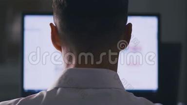后视图男子浏览电脑显示器上的互联网网站。 网页浏览，搜寻资料的概念