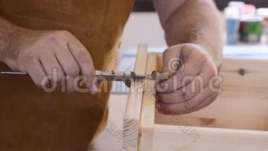 特写镜头。 有卡尺的木匠做测量.. 人与树共事.. 木匠测量，锯子