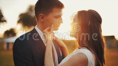 快乐微笑的年轻夫妇在户外恋爱。 接吻。 五彩缤纷的日落。 结婚纪念日。