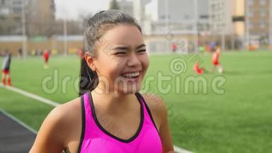 开幕式前在体育场笑的亚洲跑步女孩的肖像。