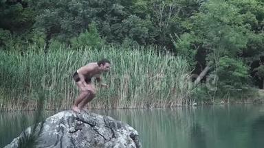 暑假或度假的年轻人从山林湖中央的石头上跳下来。 跳跃到