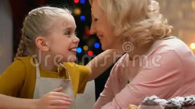 <strong>奶奶亲</strong>吻快乐的女孩，一起烘焙糕点和庆祝圣诞节