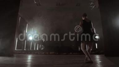 慢动作：穿黑色连衣裙的首席芭蕾舞演员表演旋转和优雅的舞蹈动作。 相机<strong>继续前进</strong>