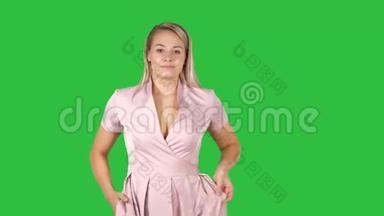 女孩<strong>走路</strong>的肖像，双手插在绿色屏幕上的粉红色衣服口袋里，Chroma键。