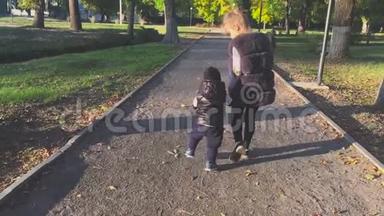 秋日公园，美女牵着手，领着小弟弟出门。
