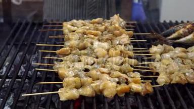 在夏季户外聚会上，男人在烧烤烧烤架上为他的朋友烹饪海鲜。 用热炭煮海上食物。