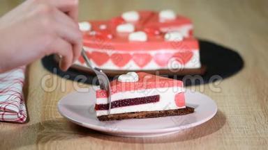 盘子里的一块红莓慕斯蛋糕。情人节那天，装饰精美的心形慕斯蛋糕。