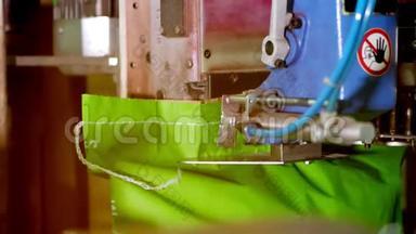 一个特写，一个特殊的自动机器缝制，缝制，纸板袋与产品，在工厂。 自动化产品
