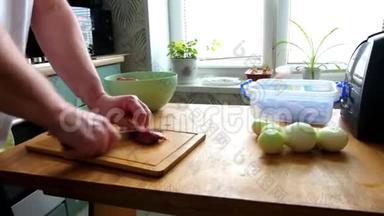 男子切鲜鱼片肉肉肉块做炒菜，双手特写.. 他在木板厨房桌子上切东西。