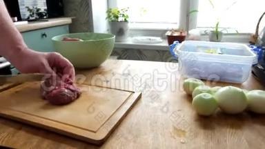 男子切鲜鱼片肉肉肉块做炒菜，双手特写.. 他在木板厨房桌子上切东西。