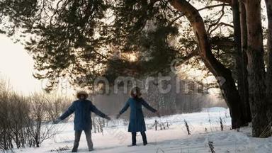 穿着蓝色羽绒服的男人和女人在冬天的森林里扔雪，微笑。 正面观点