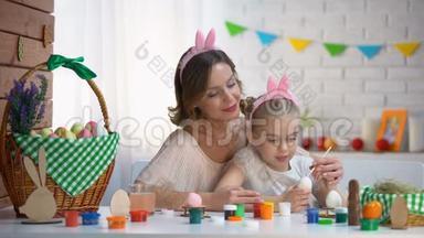 妈妈教<strong>女儿</strong>装饰鸡蛋，<strong>一家人</strong>戴着可爱的头巾坐在桌子上