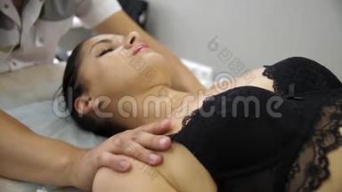 在按摩师的接待处做颈部按摩的女人。 男人`手做颈椎按摩。 女孩