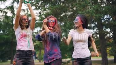慢动作欢快的女孩多民族集体跳舞，然后在公园的户外聚会上投掷油漆粉。 青年