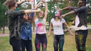 无忧无虑的年轻人在霍利节上玩得很开心，在户外跳跃、欢笑和投掷五颜六色的粉末<strong>涂料</strong>。