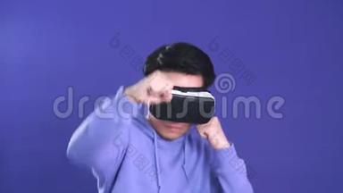 <strong>年</strong>轻人在深蓝色背景下玩虚拟现实游戏。 <strong>中国年</strong>轻人戴着VR耳机。