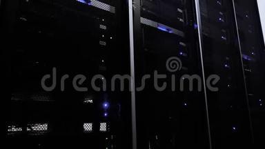 工作数据中心与一排排的机架服务器。 蓝光。 黑暗的服务器室。