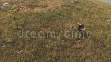 专业滑翔伞降落后的鸟瞰图沿着山的一侧走下来，滑翔伞就在它的上面