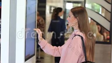 一位女士在快餐店用电子菜单在触摸屏终端点菜