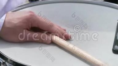 鼓手用棍子在圈套鼓上演奏。 有人手拿鼓槌，敲鼓