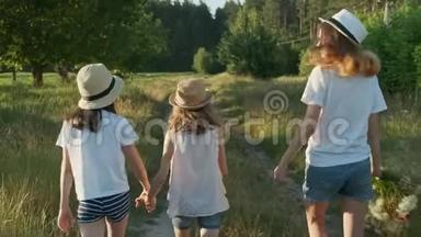 孩子们，三个戴着帽子的女孩，手牵着手，沿着乡间小路走回来