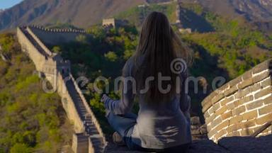 一位年轻女子坐在中国长城上沉思的慢镜头。 塔拉维尔的中国概念