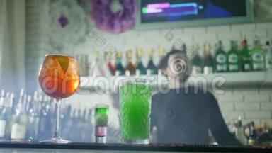 彩色鸡尾酒，新鲜浆果，近距离站立在吧台上，背景为酒保表演杂耍