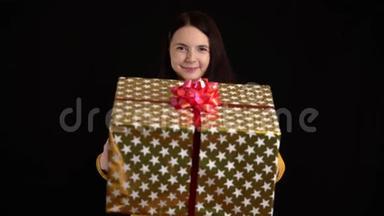 年轻女子在黑色背景上赠送礼品盒.. 带白色丝带的礼品盒，祝新年快乐，圣诞快乐